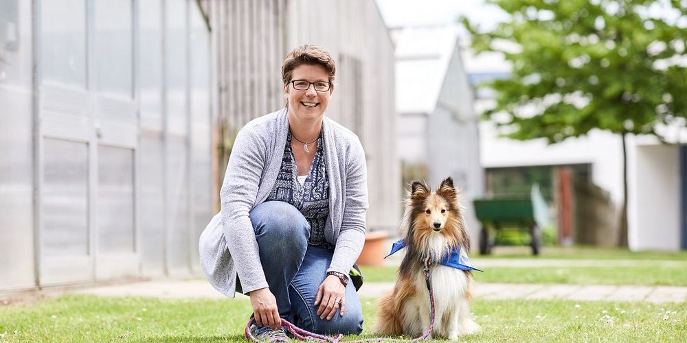 Therapeutin mit Hund bei einem tiergestützten Therapieeinsatz